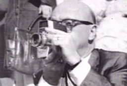 Abraham Zapruder mentre filma l'assassinio di J.F. Kennedy
